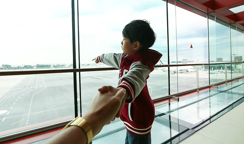 A picture of a young boy looking out of the glass panes at Changi Airport’s Viewing Gallery
